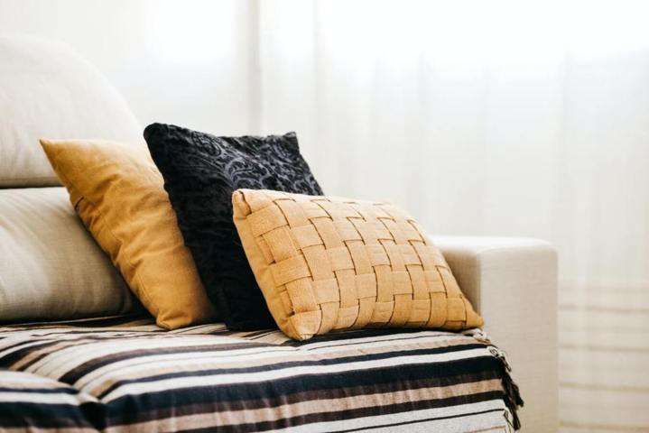 three pillows different size and pillowcase color and pattern placed on a sofa